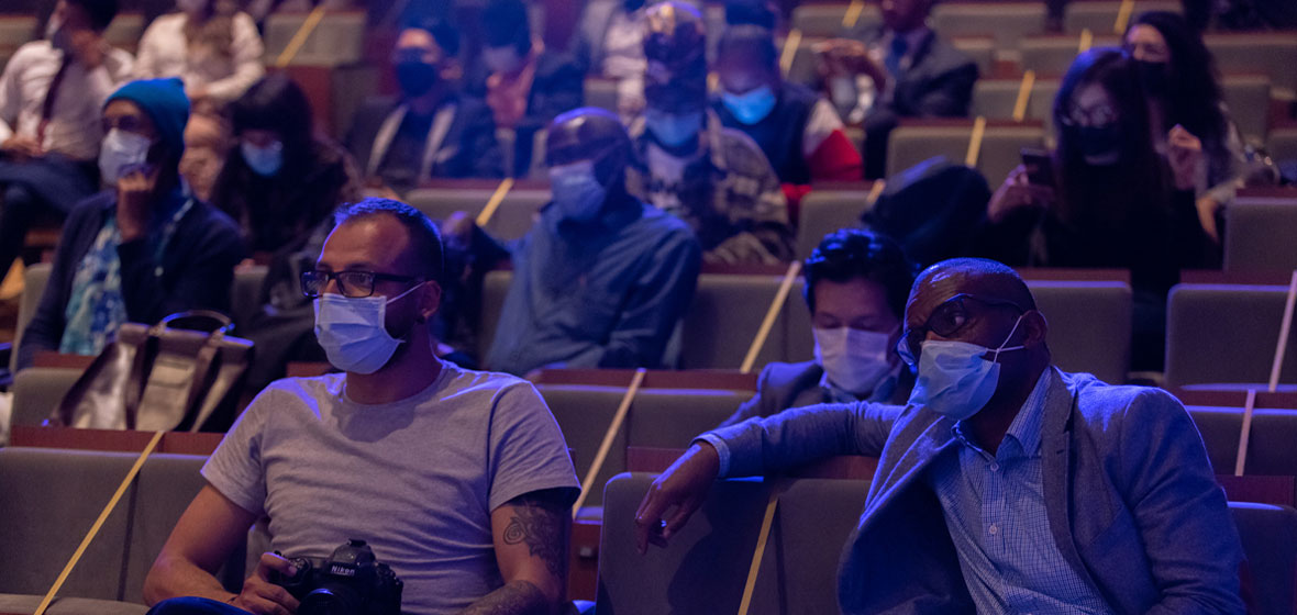 Hombres observan sentados en un auditorio