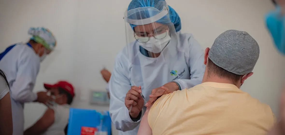 Trabajadora de la salud vacunando a un hombre