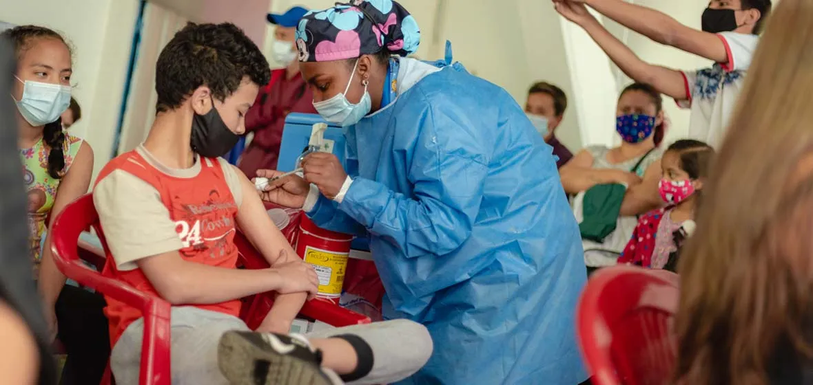 Trabajadora de la salud vacunando a un joven