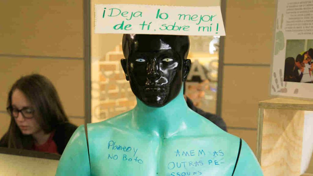 Una imagen de un maniquí con mensajes pintados sobre él. 