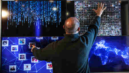 Un hombre manipula una pantalla táctil, demostrando la relación de los humanos con la tecnología.