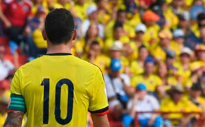 Un jugador de fútbol, de espaldas, con el número 10 y de fondo la tribuna llena. 