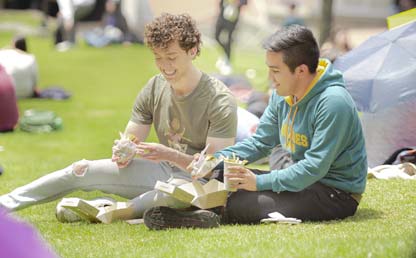 Dos estudiantes sentados en un prado