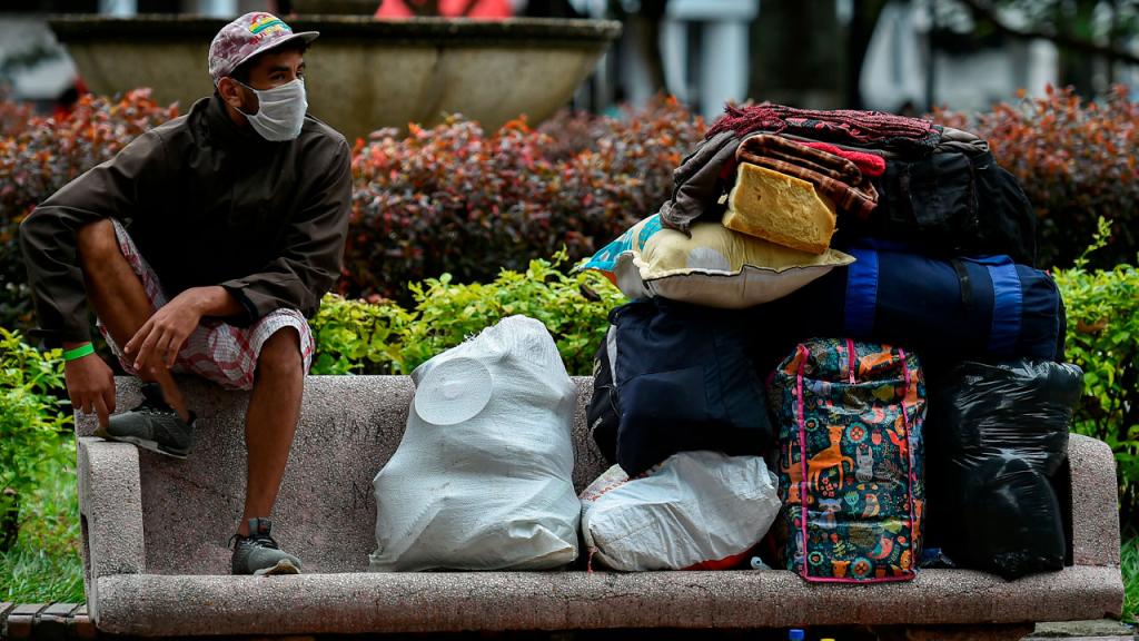 Foto de migrante venezolano con sus maletas en la silla de parque