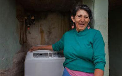 Cecilia Quiroga sonríe al pie de su nueva lavadora