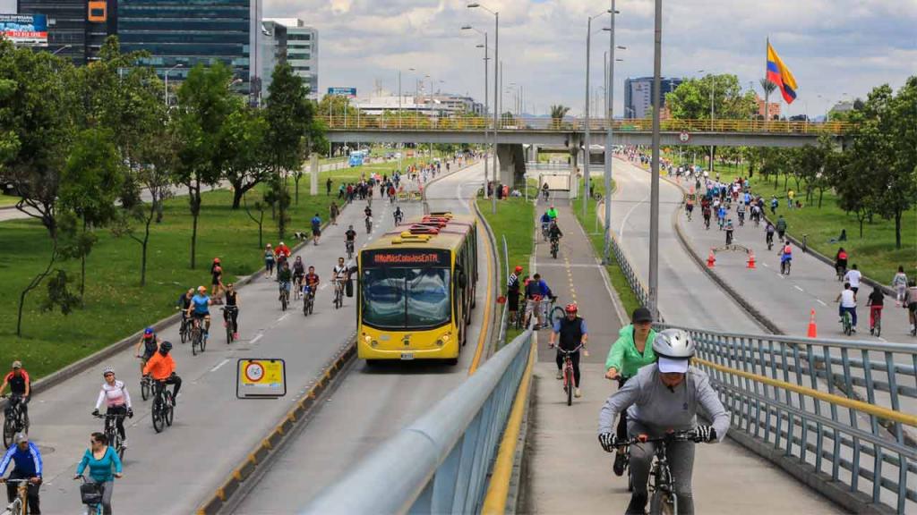 Personas montando bicicleta en una avenida de Bogotá. 