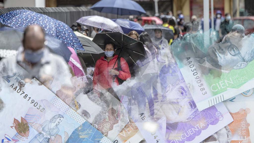 Larga fila de personas usando tapabocas a la entrada de un comercio, con collage de billetes colombianos