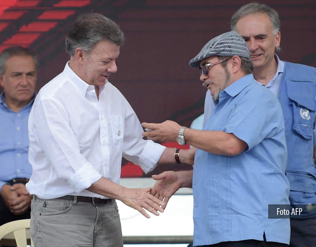 El presidente Juan Manuel Santos y Rodrigo Londoño, alias 'Timochenko', jefe de las Farc, durante el acto de entrega definitiva de armas de este grupo guerrillero.
