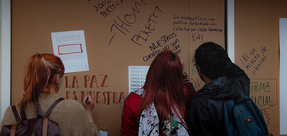 Jóvenes miran los mensajes escritos en un mural