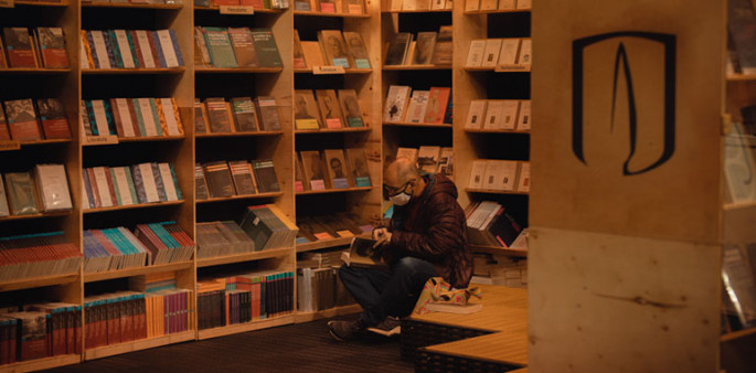 Hombre mira un libro en el estand de Uniandes