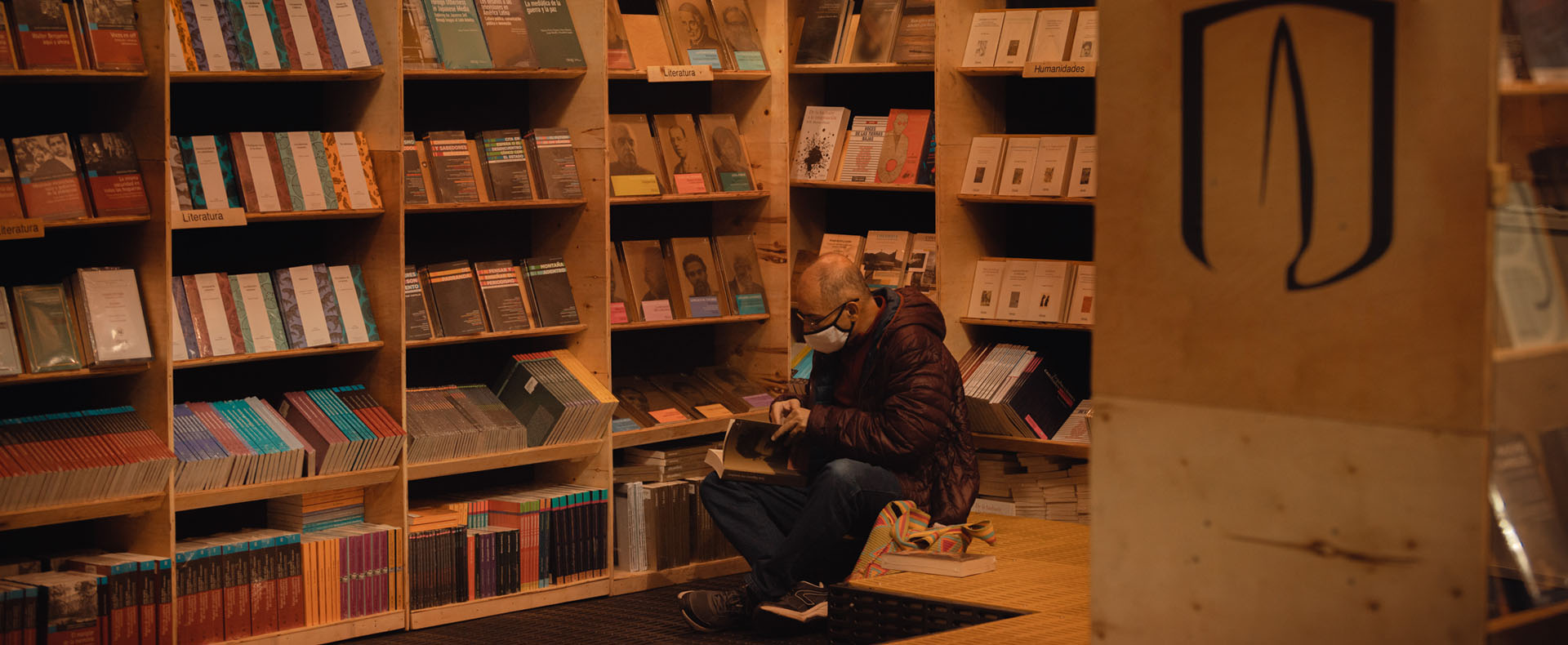 Hombre mira un libro en el estand de Uniandes