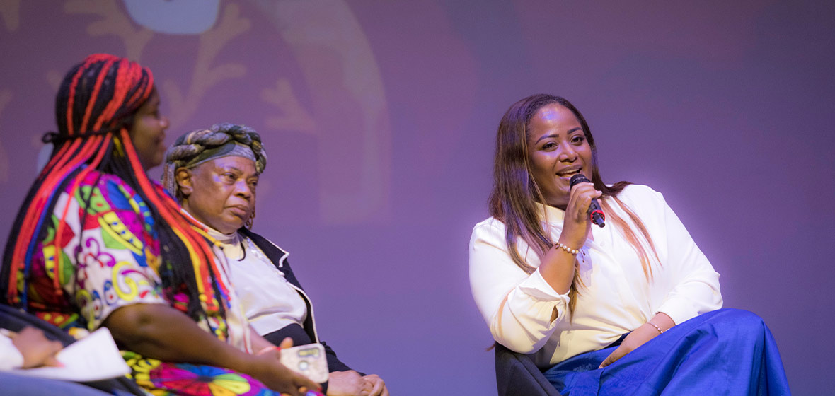 Mujeres negras hablando en un escenario.