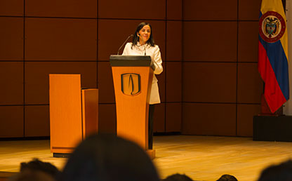 Profesora María Teresa Gómez ofreciendo discurso en ceremonia de grados