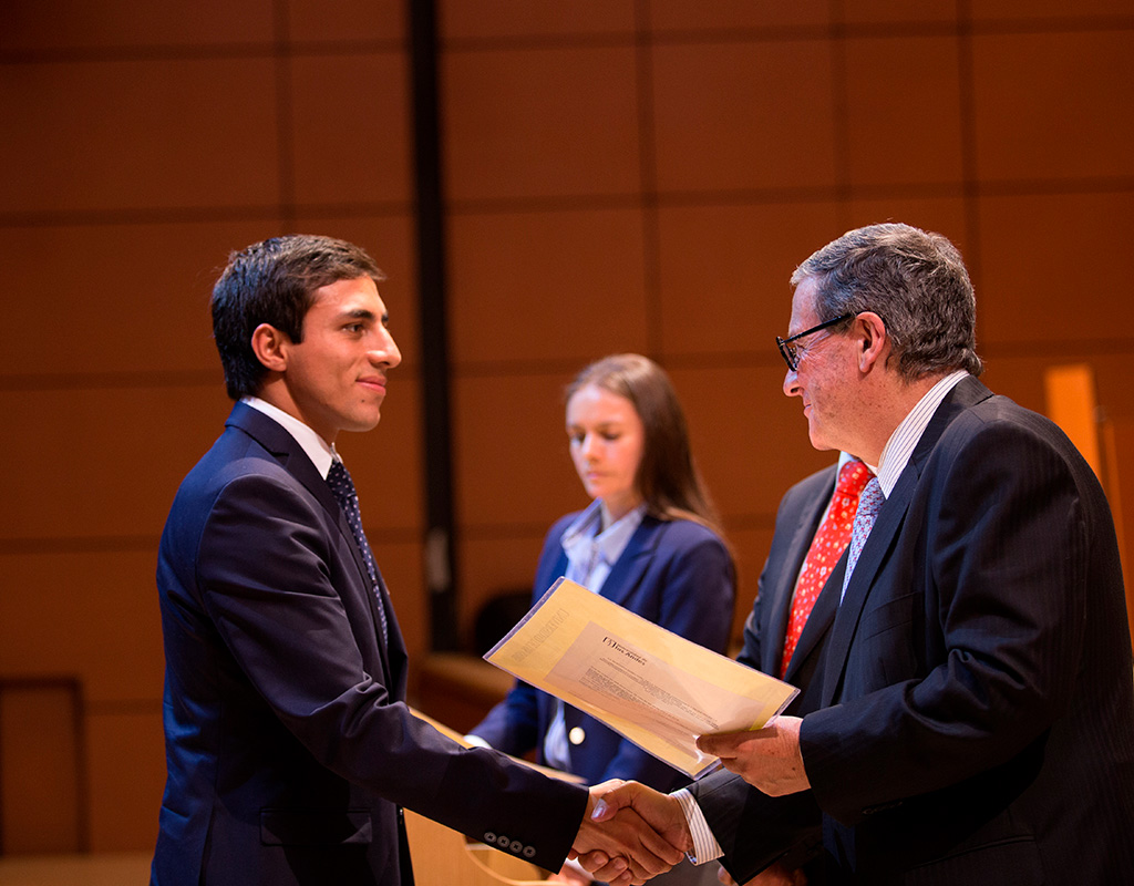 Graduando recibiendo de manos del Rector, Pablo Navas, el diploma en la ceremonia de grados 2018-1.