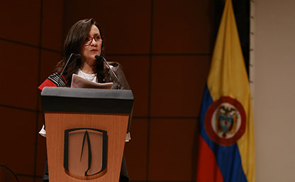 Teresa Gómez Torres, vicerrectora administrativa y financiera de la universidad de los andes frente a atril. 