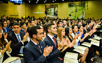 Graduandos aplaudiendo en ceremonia de entrega de grados Uniandes