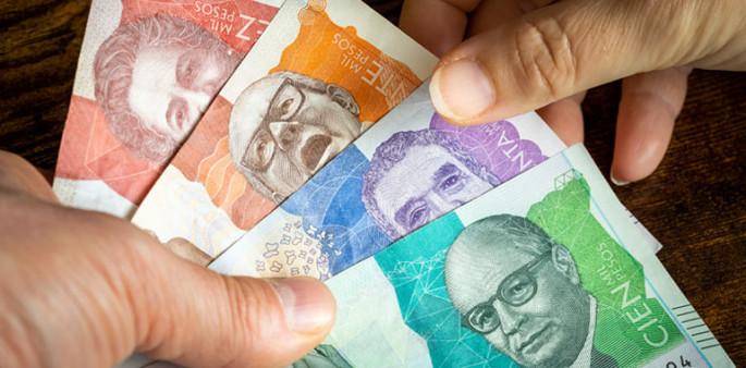 Foto de manos contando dinero colombiano
