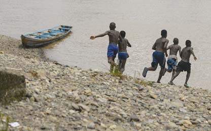 Jóvenes en Buenaventura corren hacia el mar pacífico.