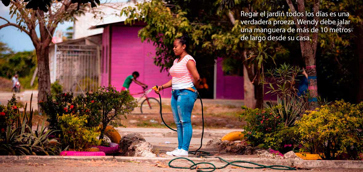 Mujer riega un jardín en Cartagena
