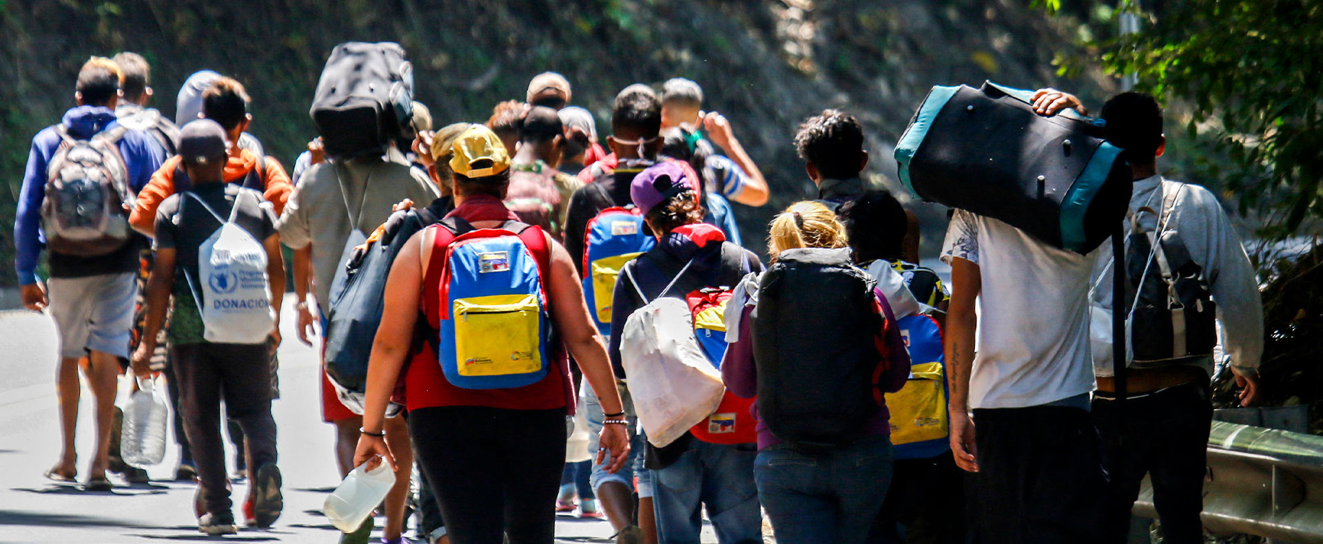 Migrantes venezolanos caminan en carretera