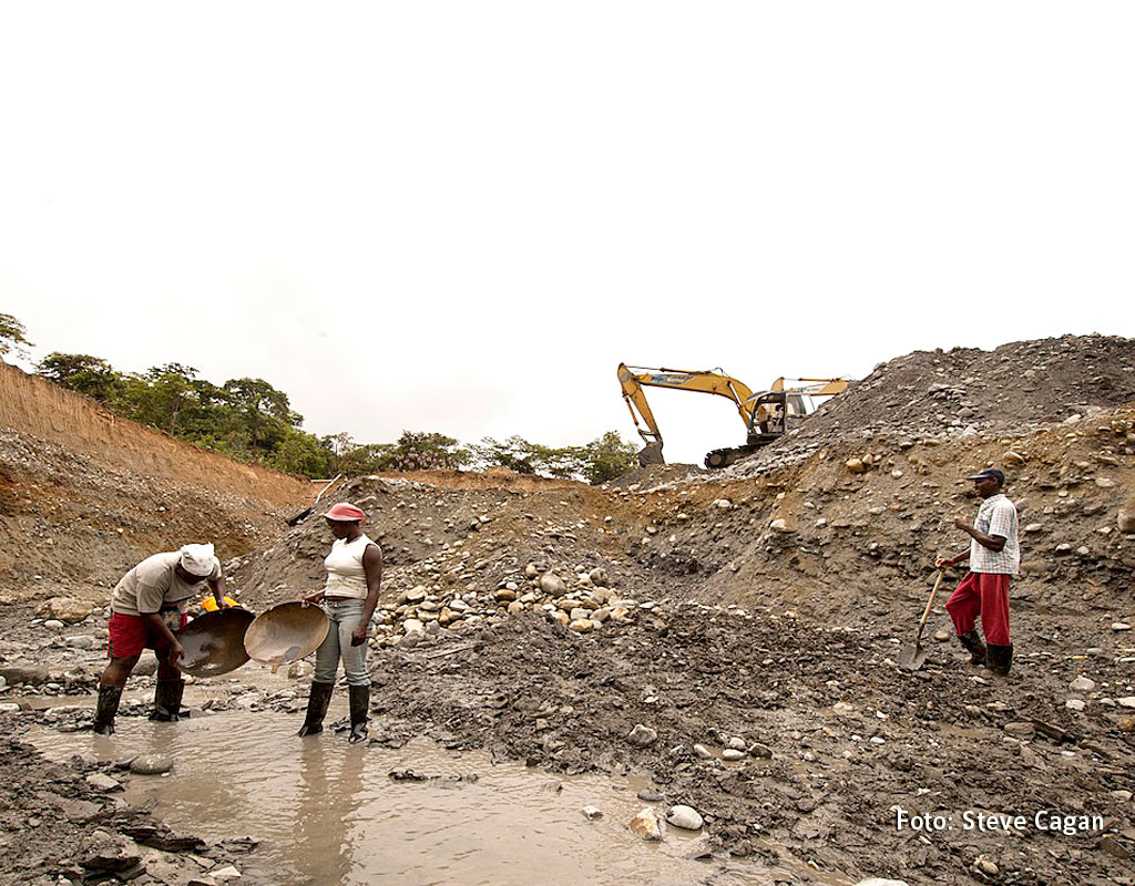 Mineros artesanales del Chocó, en Colombia. Junto a ellos, en el río, una máquina extractora.