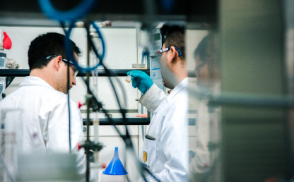 Dos hombres con bata blanca trabajan en un laboratorio. 
