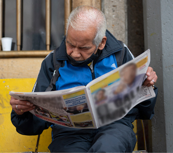 Foto de un adulto mayor leyendo el periódico 