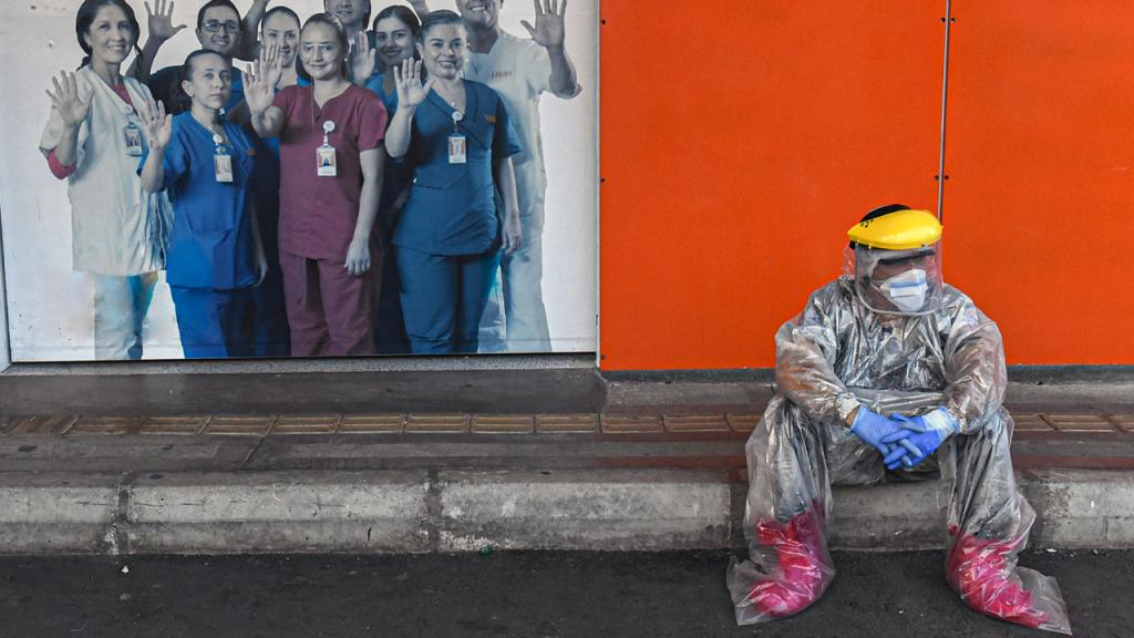 Hombre médico sentado en un andén, con elementos de bioseguridad Eduardo Behrentz