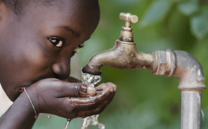 Imagen de una niña bebiendo agua de la llave.
