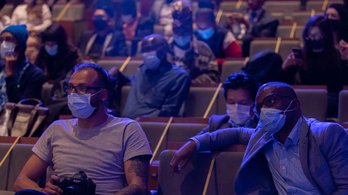 Hombres observan sentados en un auditorio