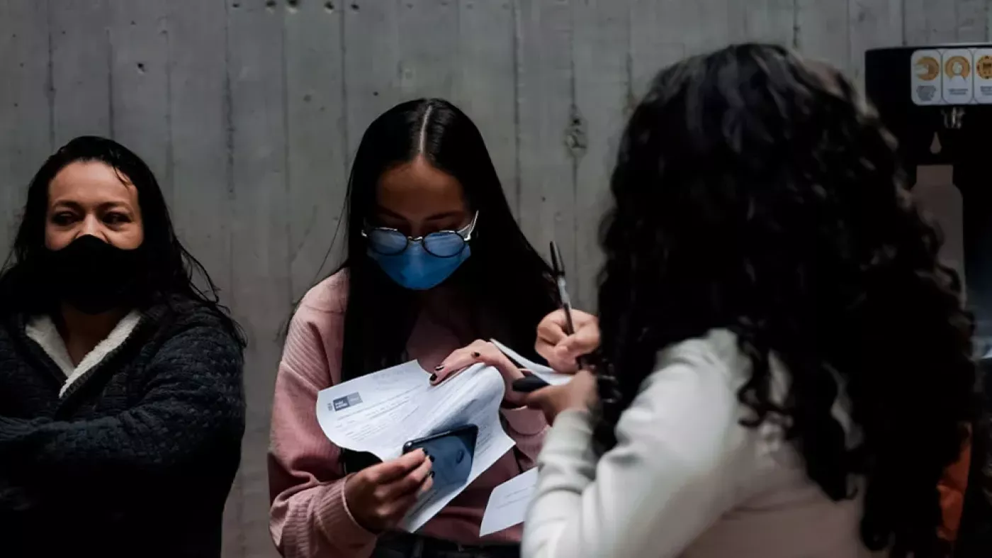 Mujeres diligenciando formatos para vacunación 