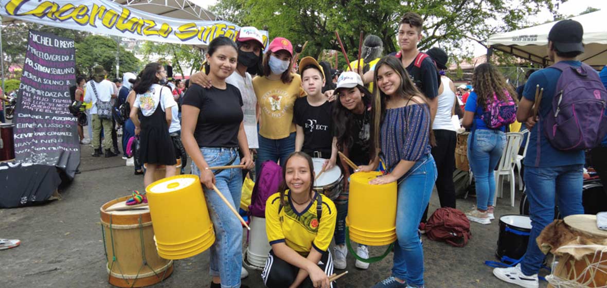 Foto de jóvenes con tambores hechos de baldes 