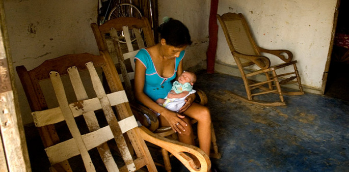 Foto de una mujer meciendo un bebé en sus brazos 