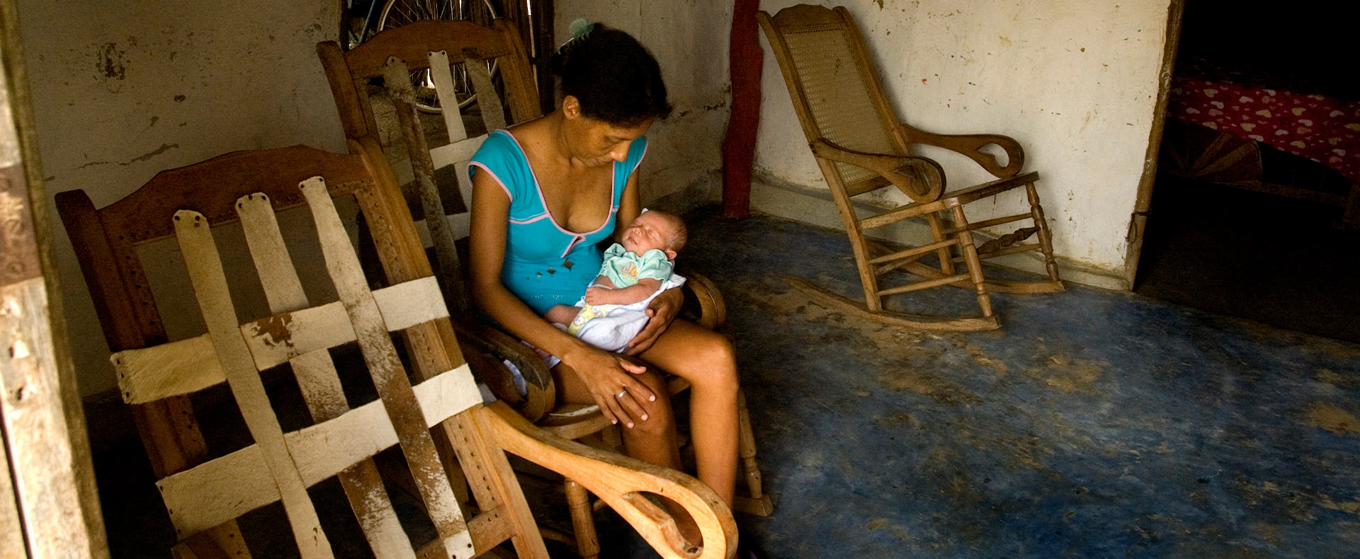 Foto de una mujer meciendo un bebé en sus brazos 